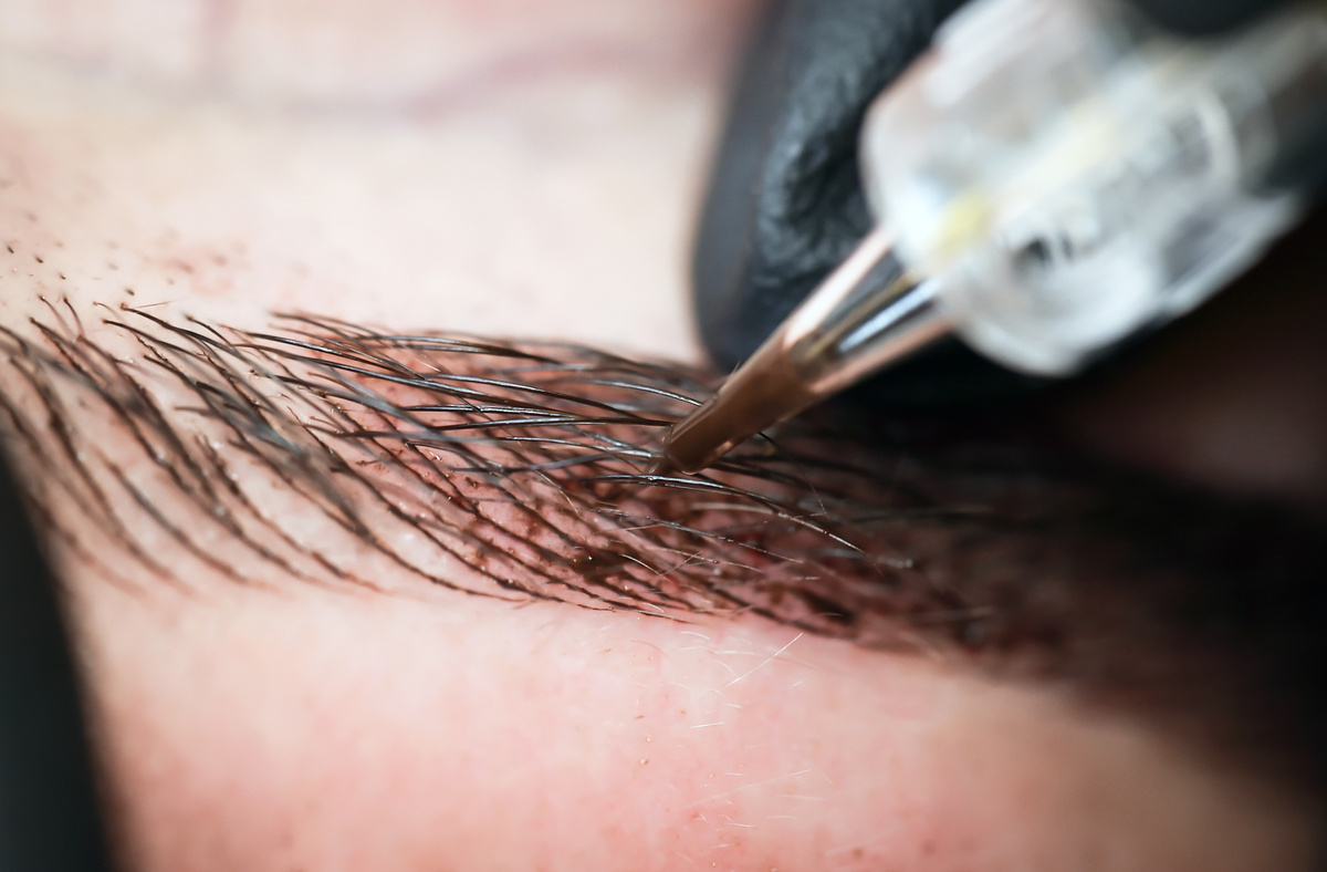 Microblading eyebrows, getting facial care and tattoo at beauty salon